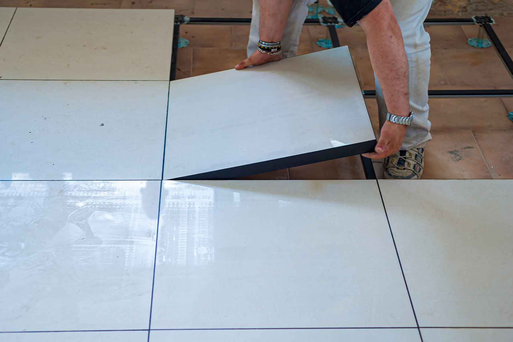 Construction worker removing used raised floor tiles